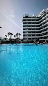 a large swimming pool in front of a large building at Cherry Top Cake Apartment in Playa del Ingles