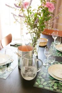 a table with glasses and a vase with flowers on it at Le Clos des Ecureuils in Saint-Héand