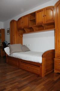 Camino Santiago Inglés Visitar Galicia في Ordes: سرير بإطار خشبي ودواليب خشبية