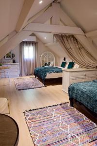 a bedroom with two beds and two rugs at Le Clos des Ecureuils in Saint-Héand