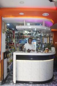 Ein Mann steht hinter einem Tresen in einem Laden. in der Unterkunft Hotel Giggle Coast Restro and Lodge in Birtamod