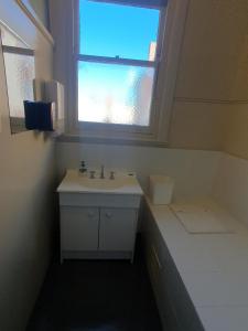 a bathroom with a sink and a window at Pier Hotel in Port Lincoln
