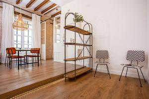 Zimmer mit einem Tisch, Stühlen und einem Regal in der Unterkunft Genteel Home Almirante Lobo in Sevilla