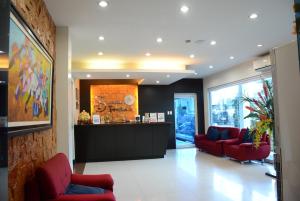 a lobby with red chairs and a reception desk at Siayan Travellers Inn in Manila