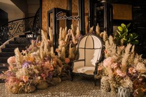 uma cadeira sentada na frente de um monte de plantas em Sanouva Da Nang Hotel em Da Nang