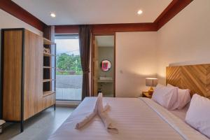 um quarto com uma cama grande e uma janela grande em Lavilla B1 New-3BR Pool Villa 15 Mins from Ubud Centre em Ubud