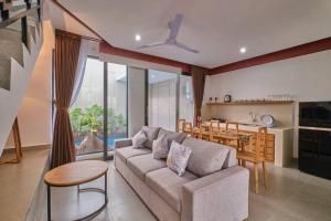 uma sala de estar com um sofá, uma mesa e uma cozinha em Lavilla B1 New-3BR Pool Villa 15 Mins from Ubud Centre em Ubud