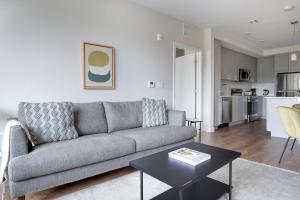a living room with a couch and a table at Brighton 2br w wd gym nr Green Line BOS-894 in Boston