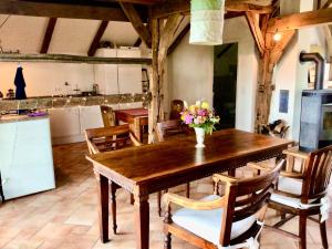 una cocina con una mesa de madera con un jarrón de flores. en Ferienhaus auf dem Bauernhof, en Bad Bentheim