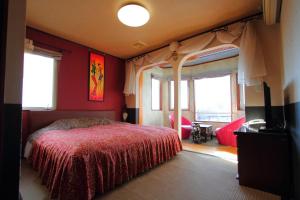 a bedroom with a bed with red walls and windows at Scotch Court in Nasu