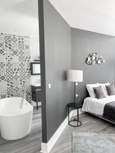 a bedroom with a bath tub and a bed at Ch&acirc;teau Lamothe in Bazi&egrave;ge