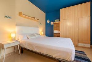 a bedroom with a white bed and a blue wall at La Cantonada in Sant Pere de Ribes