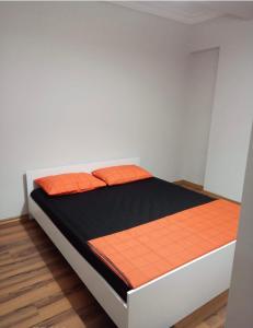 a bed with orange pillows on it in a room at İstanbul Sabiha Gökçen 2 plus 1 near to Sabiha Gokcen Airport in Istanbul