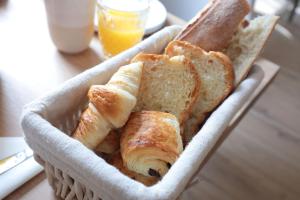 ein Korb mit Brot und Toast auf einem Tisch in der Unterkunft Pierres Blanches Guérande - Maison d'hôtes in Guérande