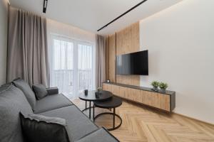 ein Wohnzimmer mit einem Sofa und einem Tisch in der Unterkunft Exclusive Apartment with Balcony & Parking Wrocław by Renters Prestige in Breslau