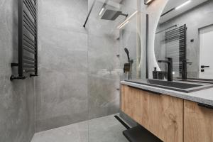 ein Bad mit einem Waschbecken und einer Dusche in der Unterkunft Exclusive Apartment with Balcony & Parking Wrocław by Renters Prestige in Breslau