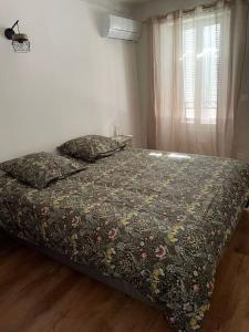 a bedroom with a bed with a flowered blanket and a window at Appartement de type duplex in Callian