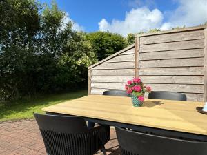 a wooden table with a vase of flowers on it at Beautiful villa close to beach and nature in Hanstholm