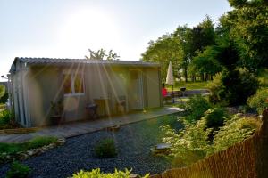 una pequeña casa en un jardín con una valla en Gîte Nature et détente en Aubréville