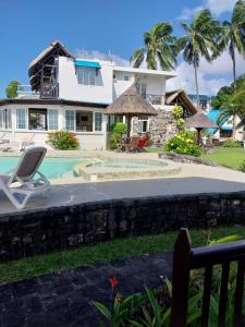 a villa with a swimming pool and a house at CHILLpill Guest House in Mahébourg
