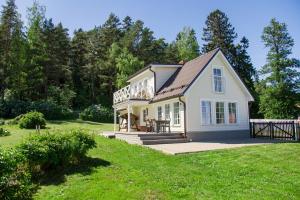ein weißes Haus mit einer Veranda auf einem Rasen in der Unterkunft Nordic Bliss beach house - Käsmu in Käsmu