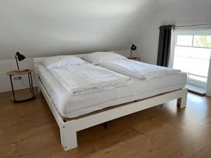 a white bed in a room with a window at WITHA in Fuhlendorf