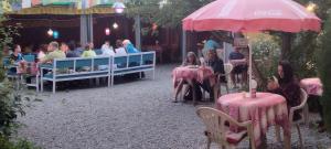 un grupo de personas sentadas en mesas en un restaurante en Mentokling Guest House and Garden Restaurant, en Leh