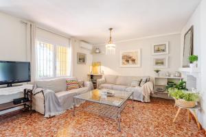 sala de estar con 2 sofás y TV en Casa Beramendi, en Torremolinos