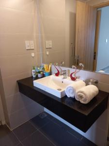 a bathroom with a sink with towels and a mirror at LY'S Căn hộ Homestay Phan Rang-2pn in Phan Rang–Tháp Chàm
