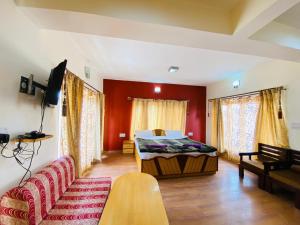 - un salon avec un lit et un canapé dans l'établissement Mentokling Guest House and Garden Restaurant, à Leh
