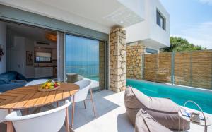 a patio with a table and chairs and a pool at Lithos Retreat 1 in Kalamata