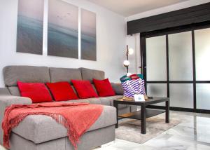 sala de estar con sofá gris y almohadas rojas en Second line Puerto Banús top floor, en Marbella