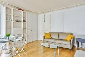 ein Wohnzimmer mit einem Sofa und einem Tisch in der Unterkunft Appartement Quartier Champs-Élysées 3 in Paris