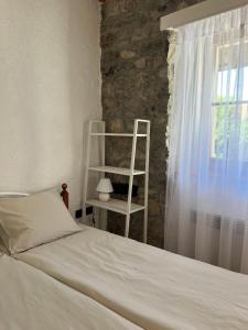 um quarto com uma cama branca e uma janela em Guesthouse 45 em Dutovlje