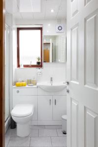 a white bathroom with a toilet and a sink at Bothwell Court Apartments in Dunfermline