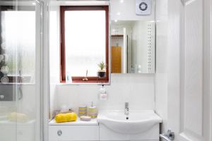 a white bathroom with a sink and a mirror at Bothwell Court Apartments in Dunfermline