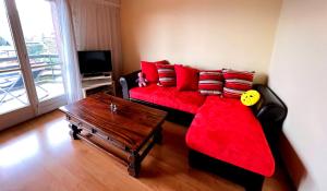 a living room with a red couch and a table at Triplex in Villars Centre with Parking in Villars-sur-Ollon