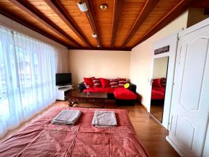 a living room with a couch and red pillows at Triplex in Villars Centre with Parking in Villars-sur-Ollon