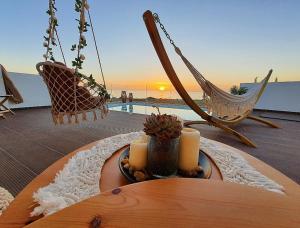 stół ze świecami i krzesłami na patio w obiekcie Tramonto Luxury Villa No1- Breathtaking sunset view w mieście Karpatos