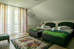 a bedroom with two beds and a rug at Lacrima Izei in Săcel