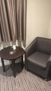ein Wohnzimmer mit einem Stuhl und einem Couchtisch in der Unterkunft Perfect Stay Dubai in Dubai