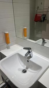 Perfect Stay Dubai في دبي: بالوعة بيضاء في الحمام مع مرآة