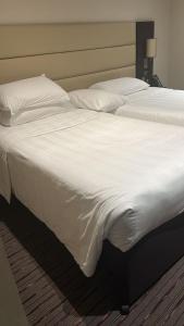 a large bed with white sheets and pillows at Perfect Stay Dubai in Dubai