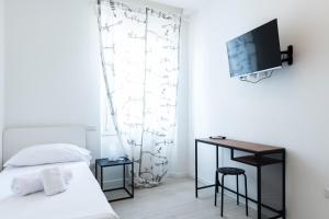 ein Schlafzimmer mit einem Bett und einem TV an der Wand in der Unterkunft Casa Maglò camere in Verona