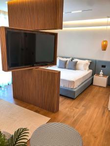 a bedroom with a bed with a large flat screen tv at Hotel Teuta in Ulcinj