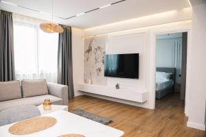 uma sala de estar com um sofá e uma televisão na parede em Hotel Teuta em Ulcinj