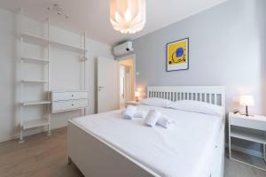 a white bedroom with a large white bed and a desk at Casa Maglò camere in Verona