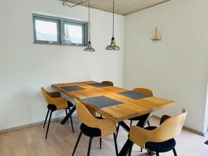 una mesa de madera y sillas en una habitación en Beautiful villa close to beach and nature, en Hanstholm