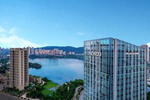 Blick auf ein großes Glasgebäude mit einem Wasserkörper in der Unterkunft Hotel Indigo Changsha Meixi Lake in Changsha