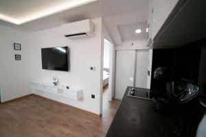 sala de estar con paredes blancas y TV en la pared en Luxury Apartments Una Sarajevo, en Sarajevo